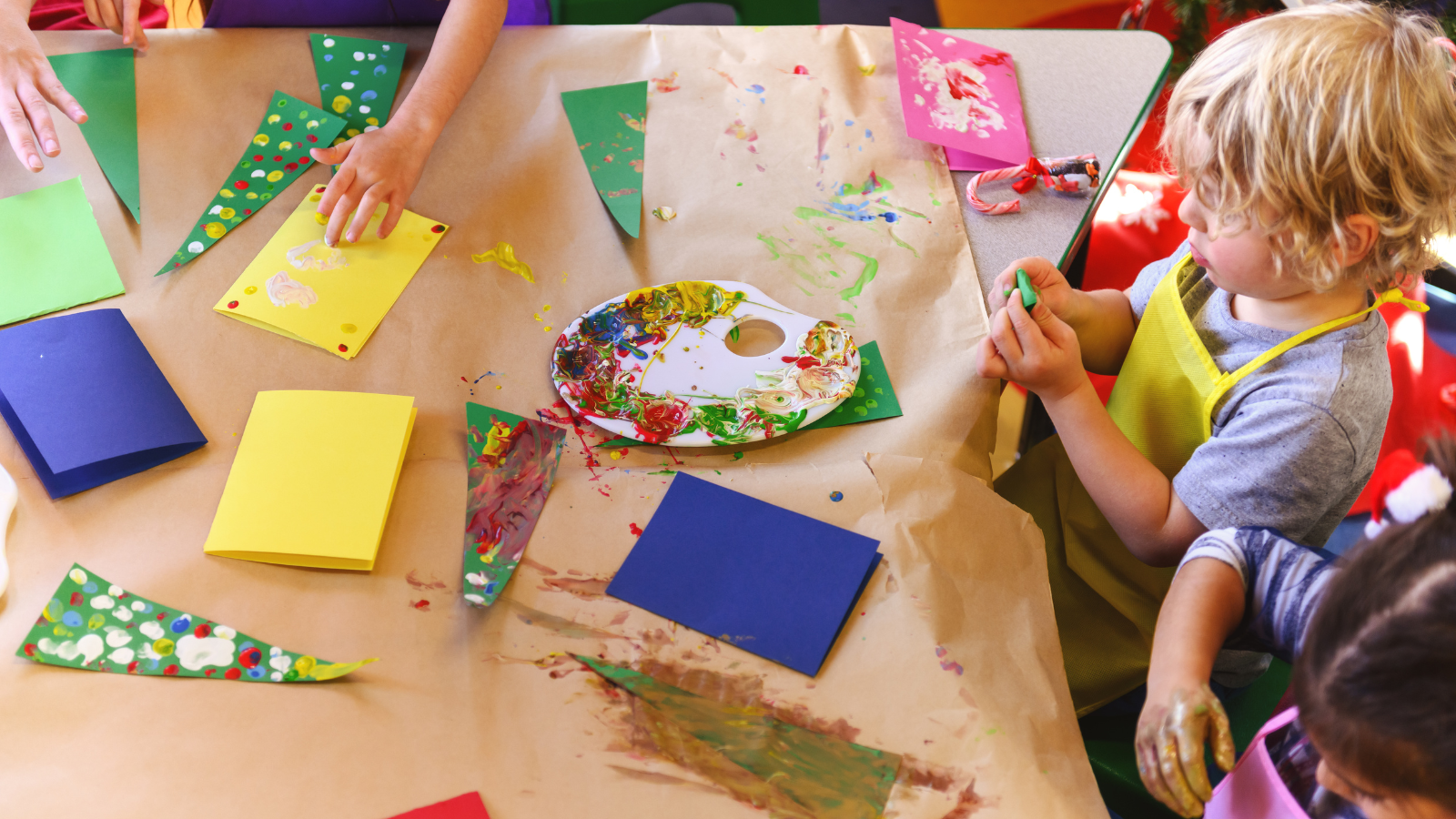 Kinderen in de klas maken een papieren kerstboom.