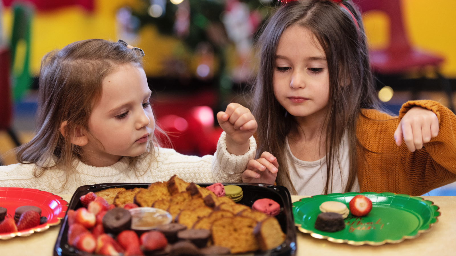 Leerlingen smullen van kerstlekkernijen in de klas.